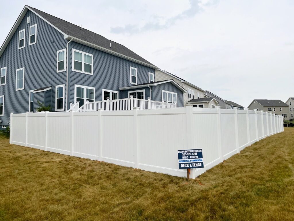 White vinyl privacy fence around a backyard